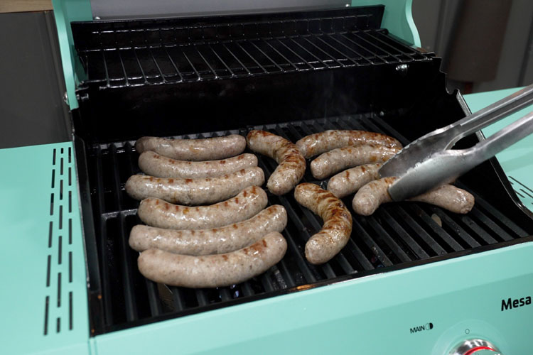brats being cooked on the grill