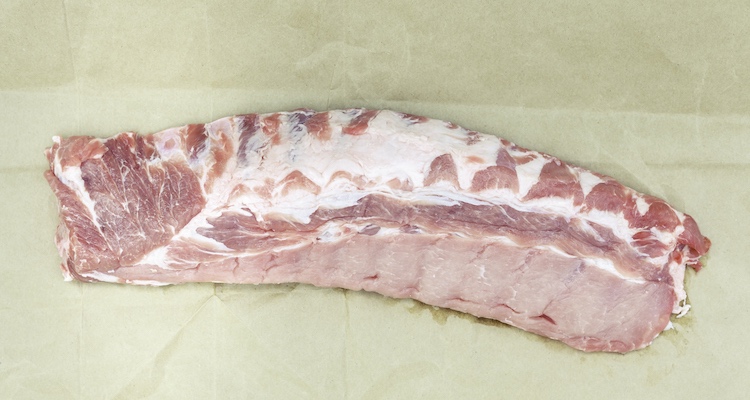 uncooked baby back pork ribs on a parchment paper