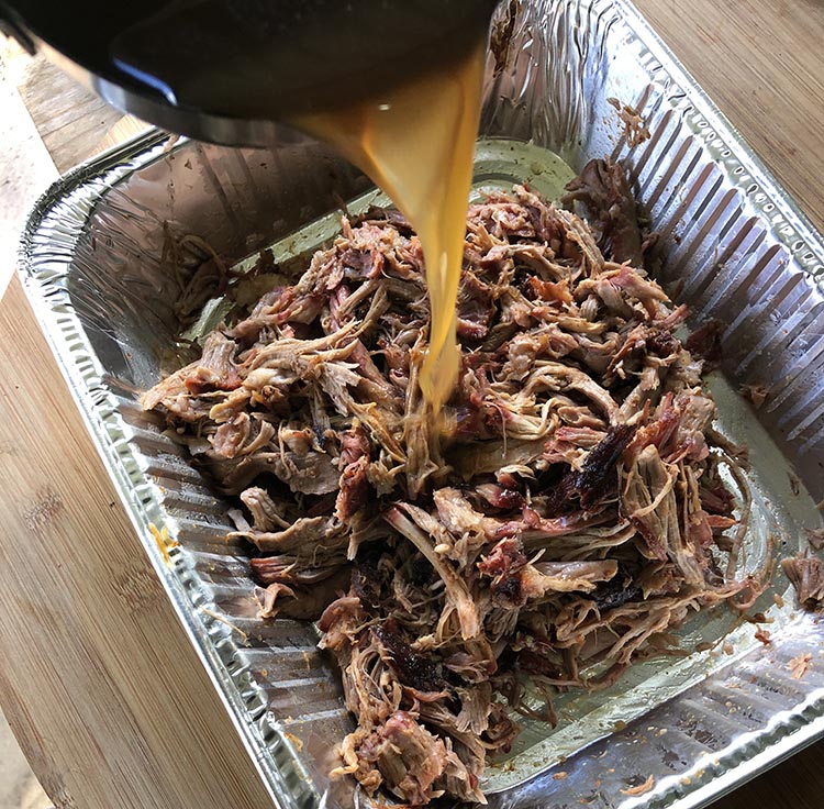 pouring sauce over bbq pulled pork
