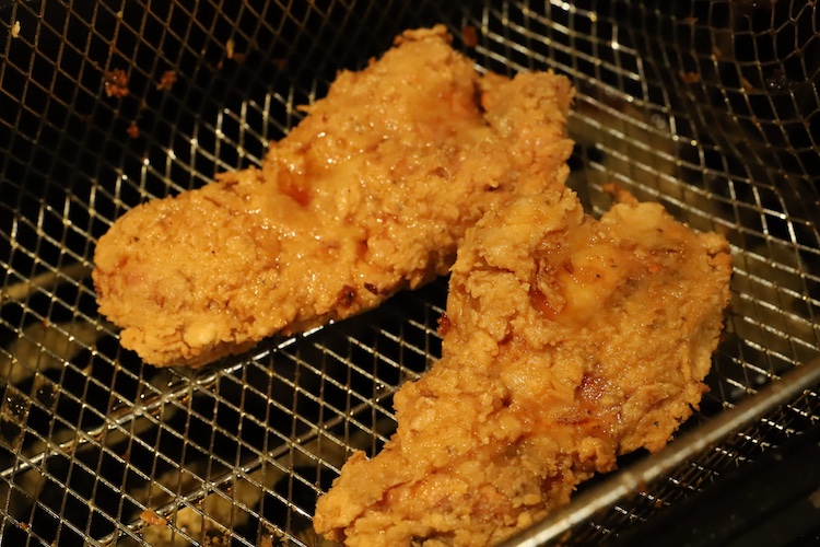 fried chicken thighs in a fryer basket