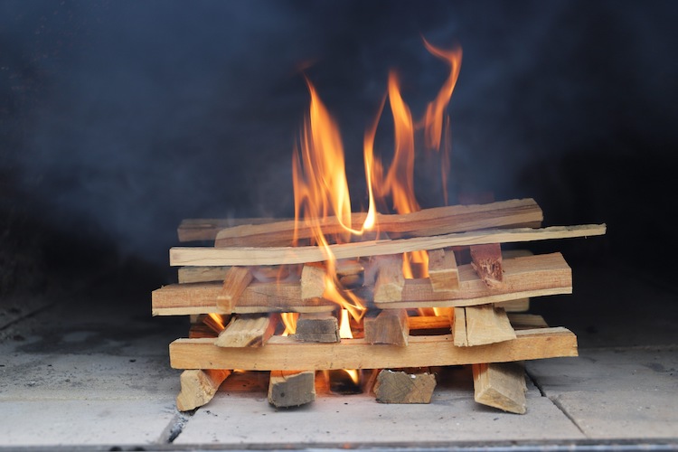 burning hardwood kindling in a pizza oven