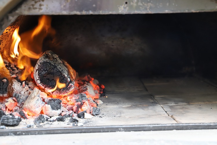 burning coals in a wood fired pizza oven
