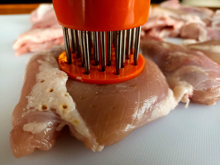 poking holes in a raw chicken thigh with jaccard