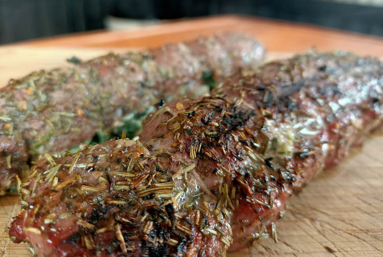 grilled lamb backstraps on a wooden board