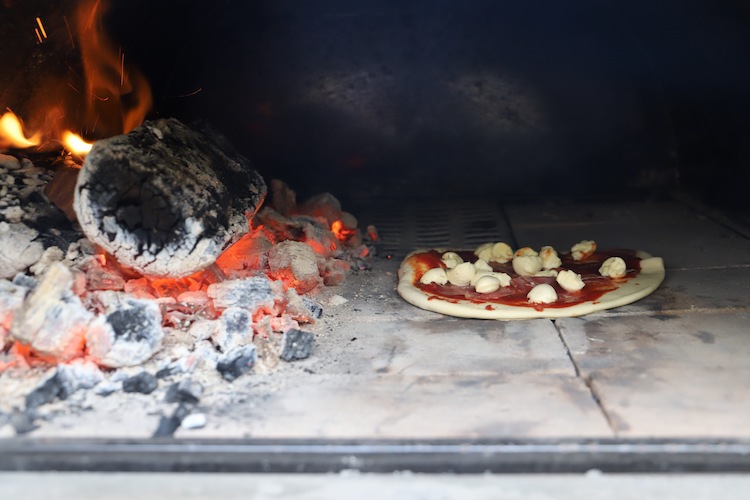 pizza cooking in a wood fired pizza oven