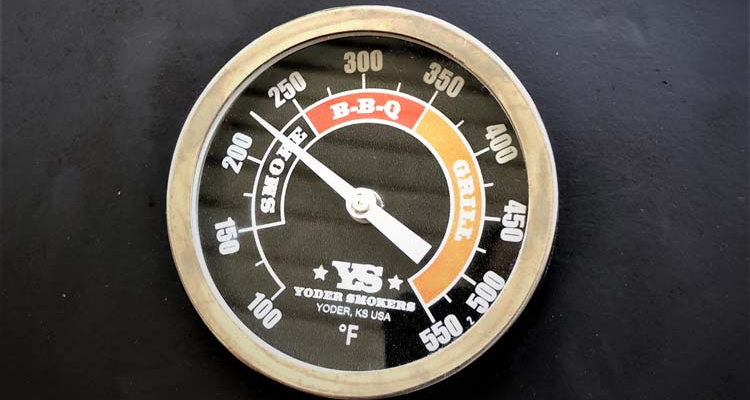 close up showing built-in smoker thermometer with different tempreature numbers for smoking and grilling.