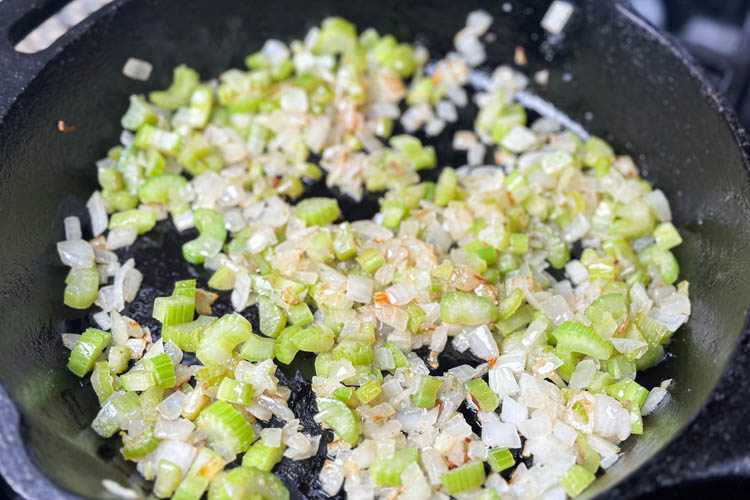diced celery and onion frying in a skillet