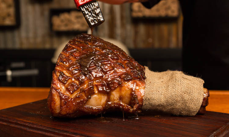 applying glaze to a smoked ham