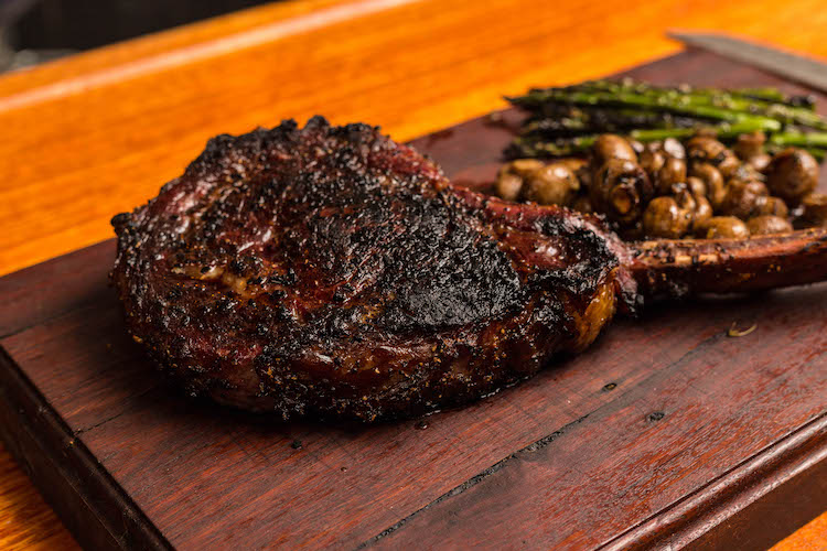 reverse seared tomahawk steak on a wooden board