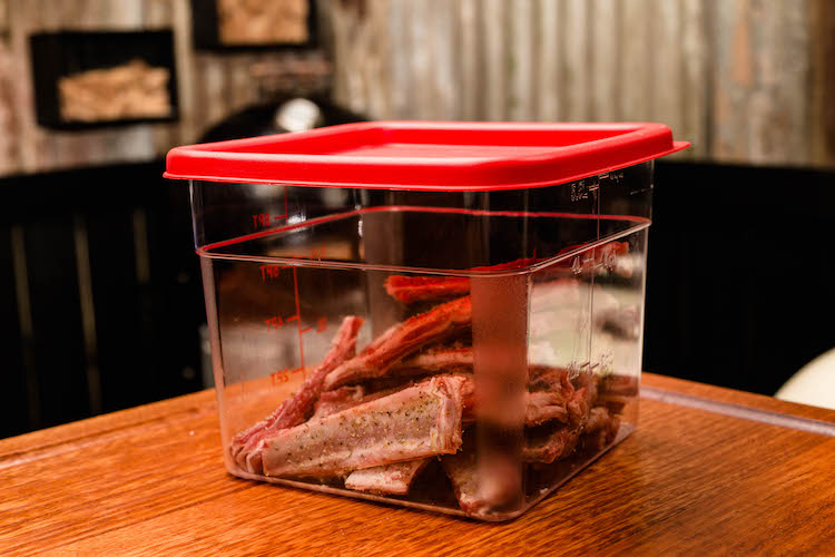 seasoned lamb ribs in a plastic container