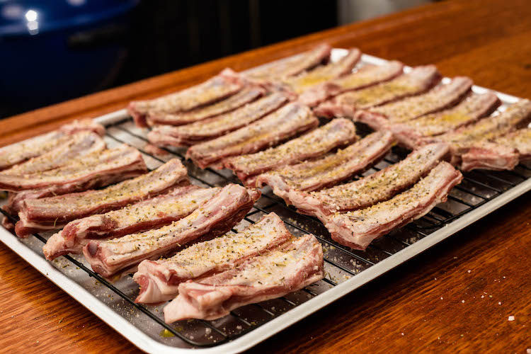 seasoned lamb ribs on a metal tray