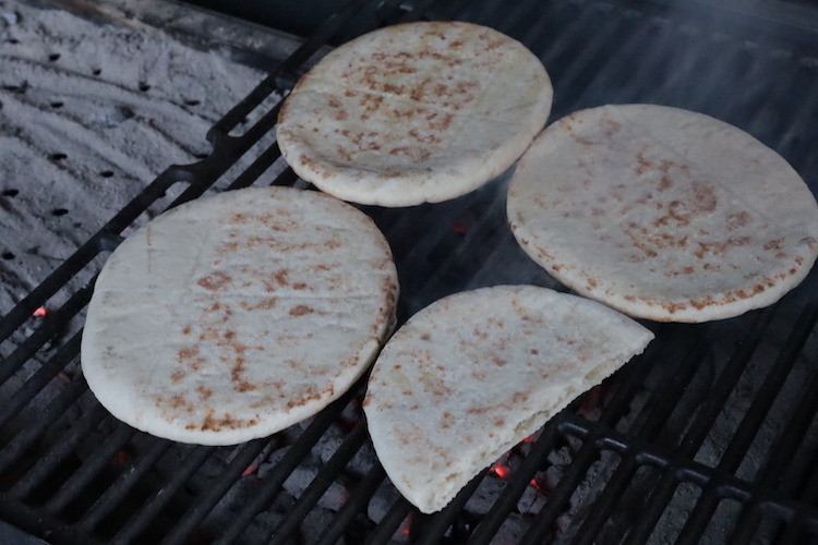 pieces of pita bread heating up on a grill