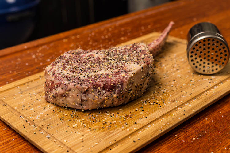 seasoned tomahawk steak on a wooden board