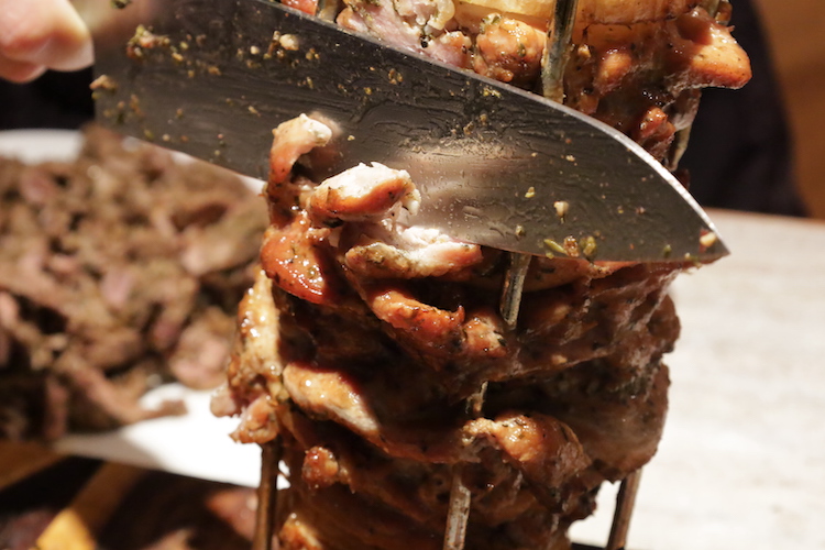 slicing pieces of cooked lamb shoulder