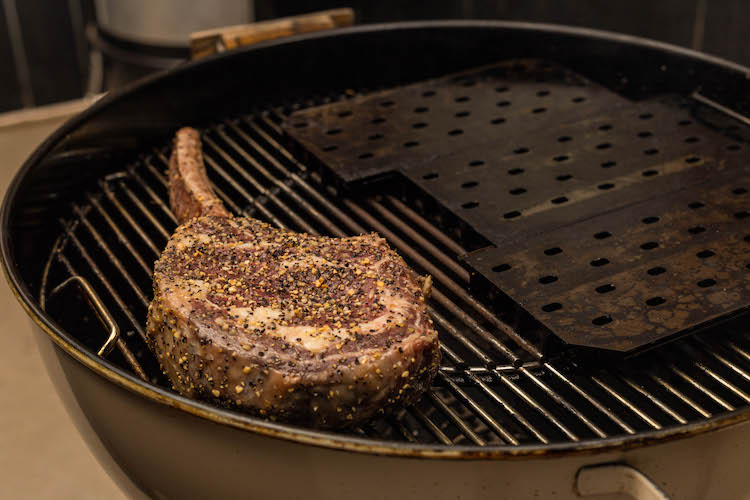 tomahawk steak on a Weber kettle grill