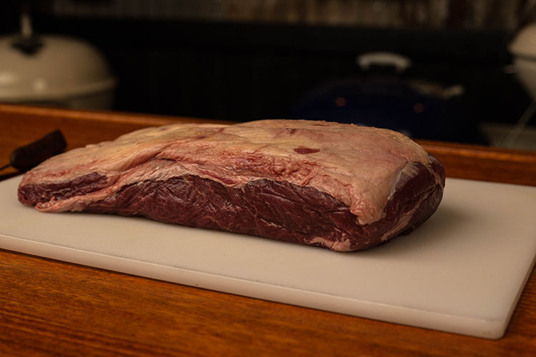 beef flat iron steak on a plastic board
