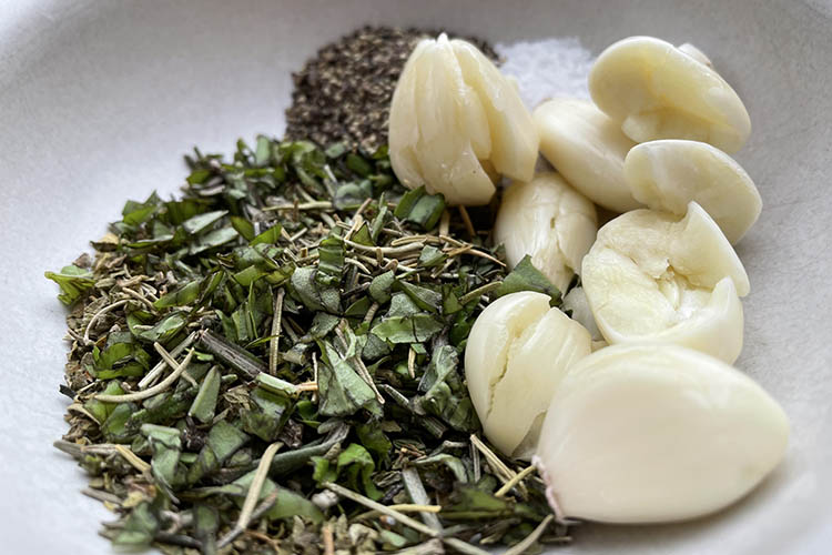 herbs, spices and garlic cloves in a bowl