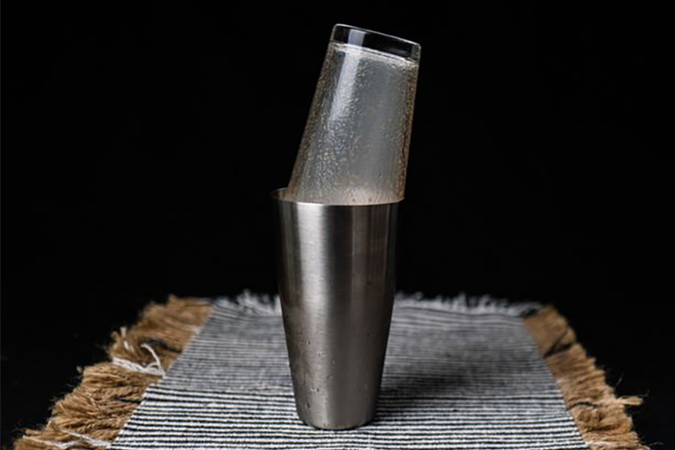 a glass capturing the smoke inside a cocktail shaker