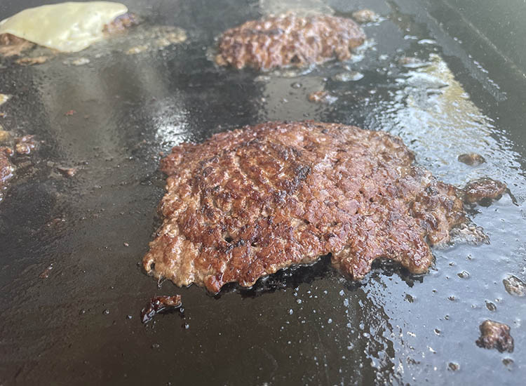 cooked smash burger patty on a griddle