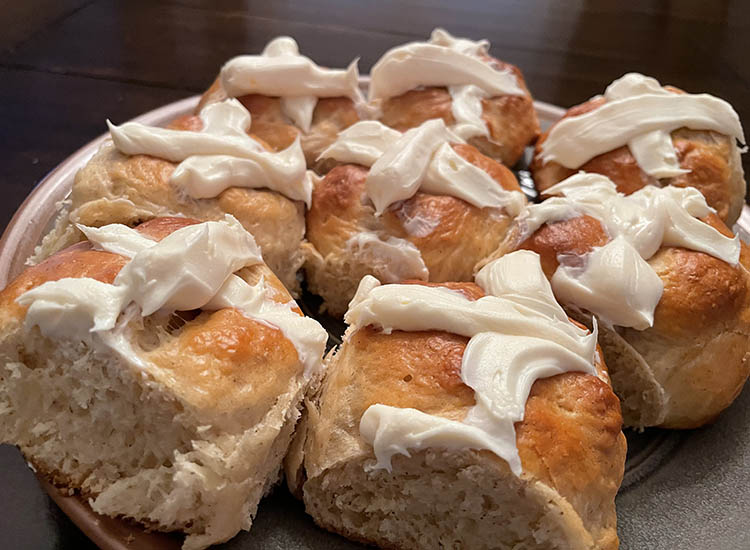 cooked hot cross buns with icing on a plate