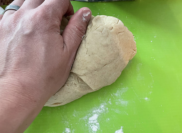 a man kneading the dough with his hand