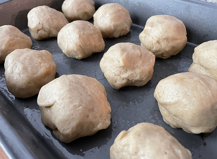 uncooked dough balls on a metal baking tray