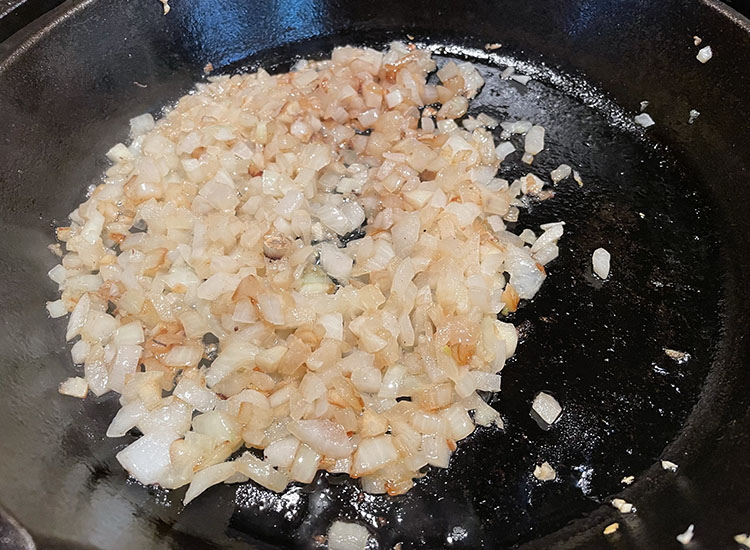 fried chopped onions in a cast iron pan