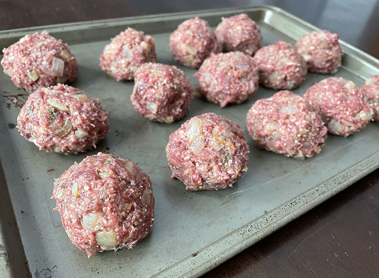 raw venison meatballs on a metal tray