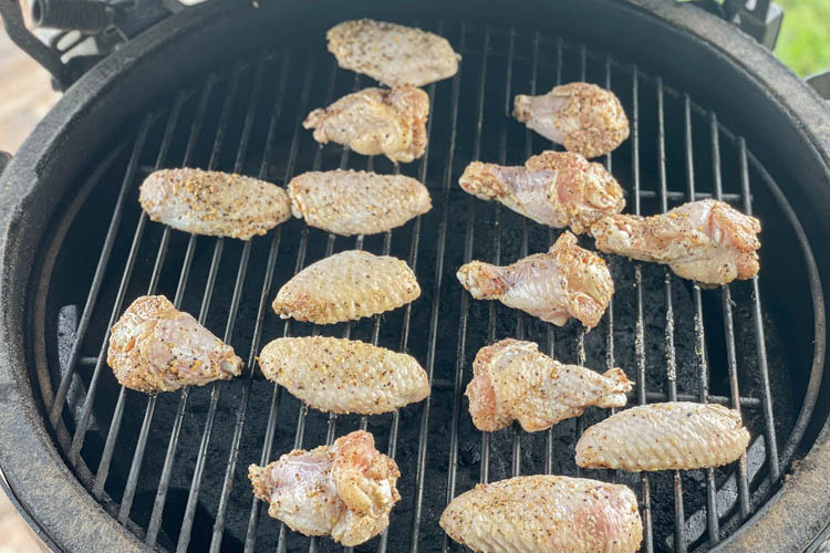 raw, seasoned chicken wings on grill