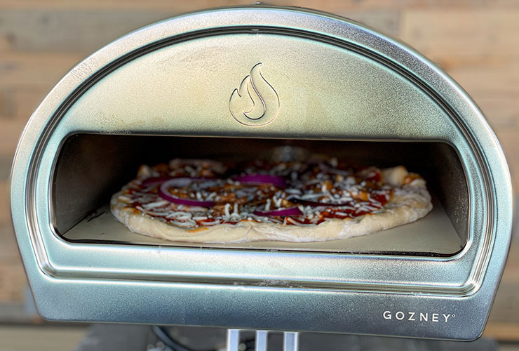 a close up of Gozney Roccbox pizza oven with pizza cooking inside