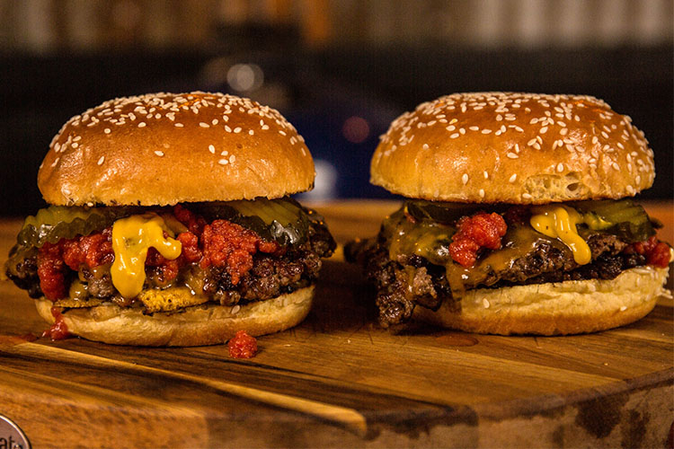 cooked smash burgers on a wooden board