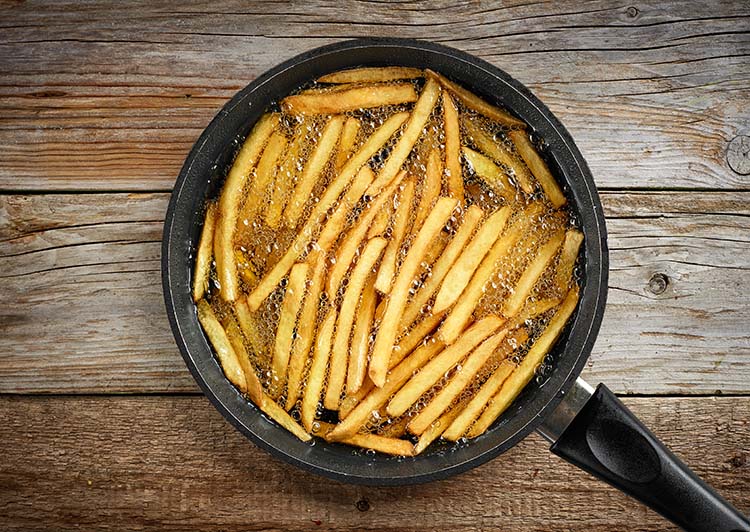 frying french fries in a pan with oil