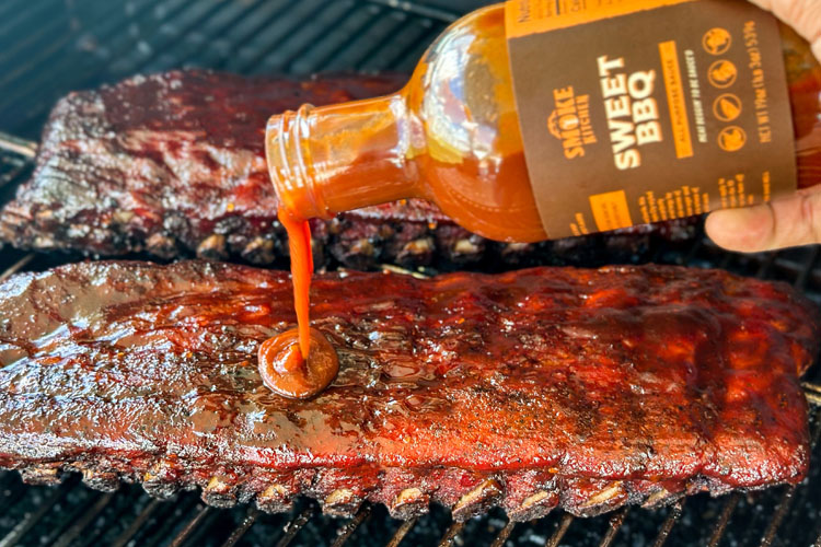 smoke kitchen sweet bbq sauce being drizzled on ribs