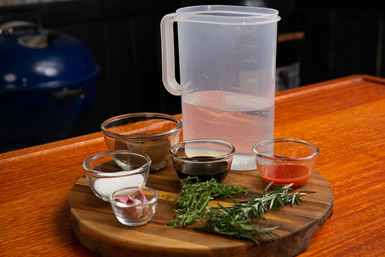 Chicken wing brine ingredients prepped in individual containers on a wooden tray