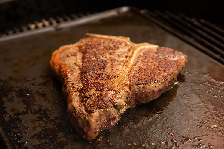 grilled porterhouse steak on a griddle
