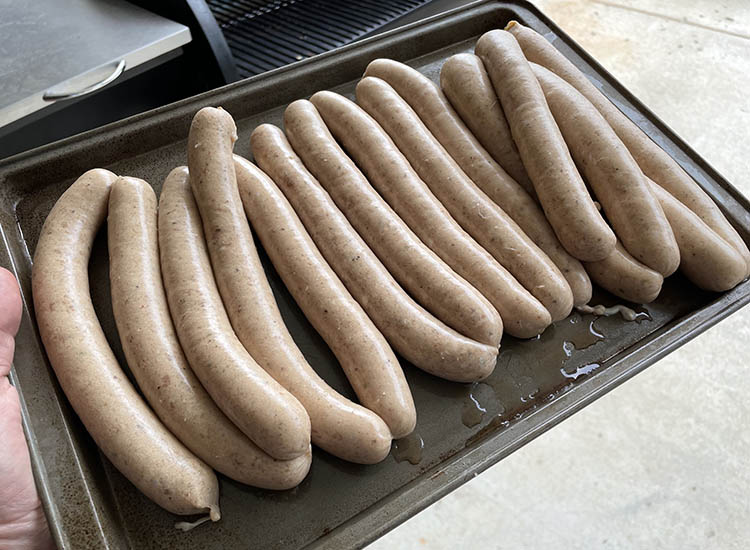 uncooked hotdogs on a metal tray