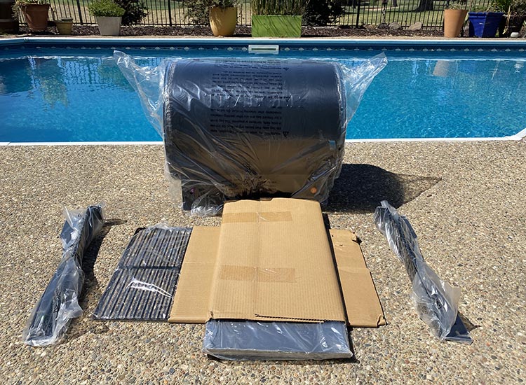 traeger tailgater unassembled with separate parts wrapped in plastic and cardboard
