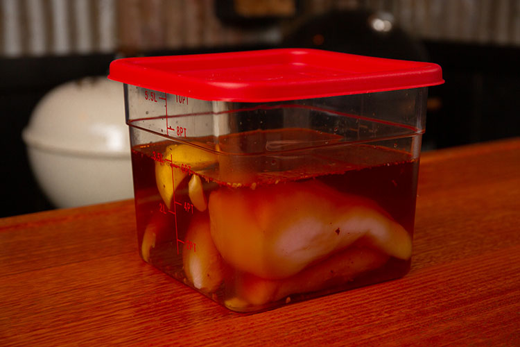 Chicken breast in a container with wet brine