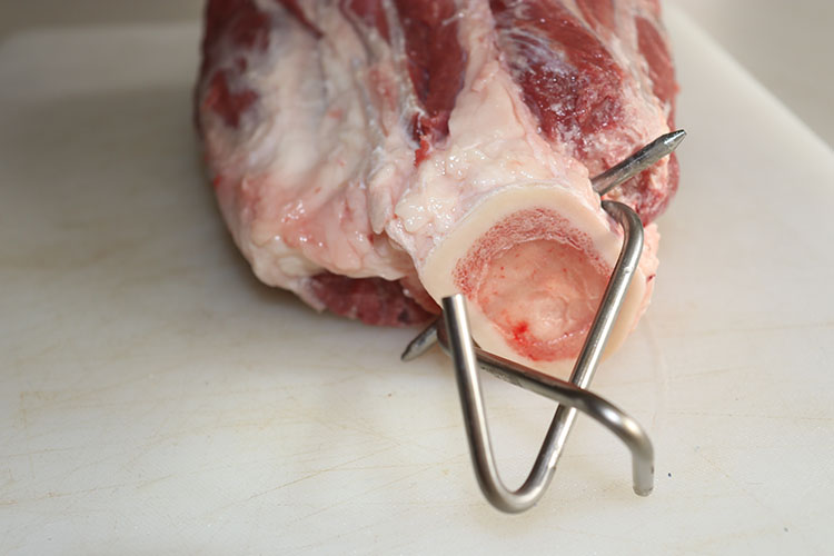 beef shank with 2 hooks attached through the bone