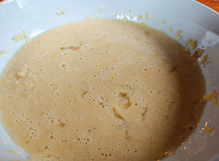 breadcrumbs, milk and egg mixture in a white bowl