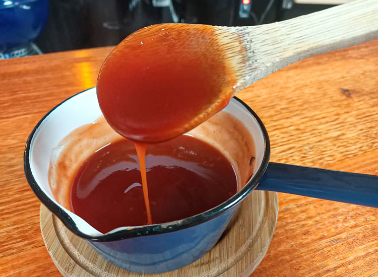 glazing sauce in a saucepan with a wooden spoon