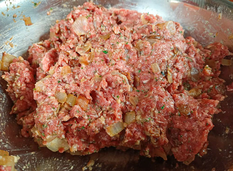 mixed meatloaf ingredients in a metal bowl