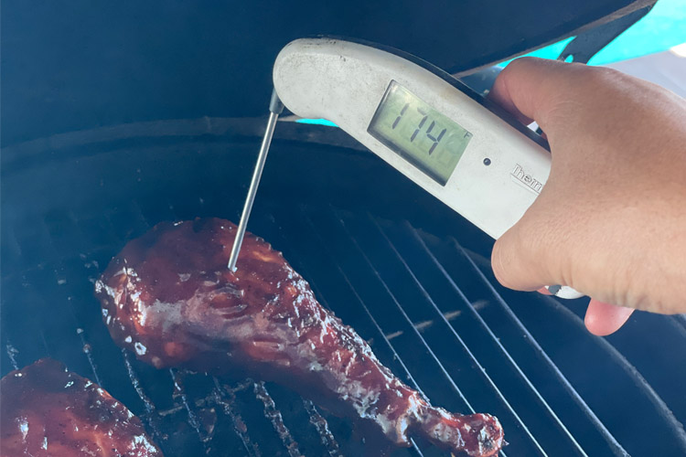 turkey leg with instant read thermometer reading 174 degrees Fahrenheit