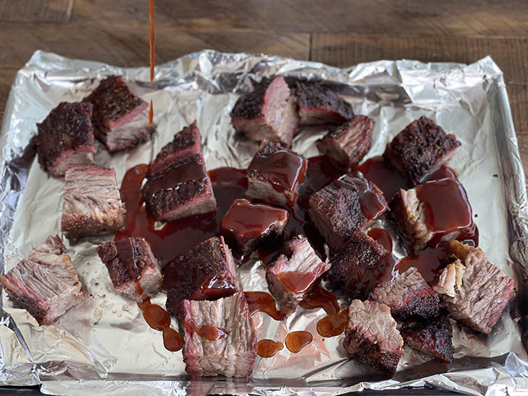 brisket point cubes with bbq sauce on a baking tray