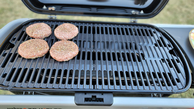 burger patties grilling on a weber traveler gas grill