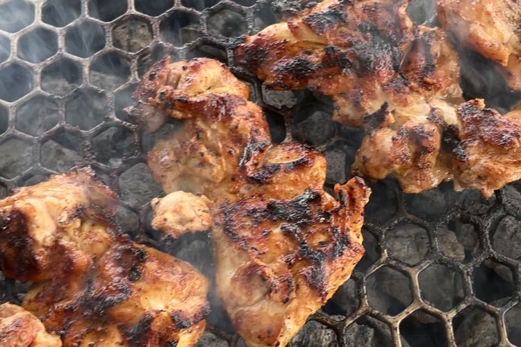 chicken thighs cooking on a grill