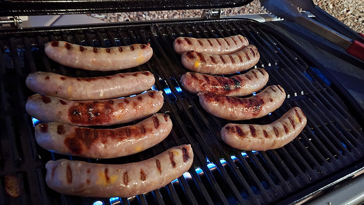 grilling bratwurst links on a weber traveler gas grill