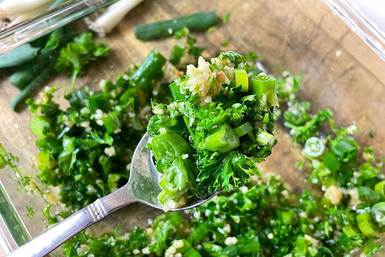 fork holding chopped up parsley salad