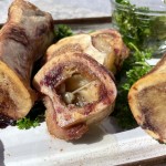 cooked smoked bone marrow on a white platter