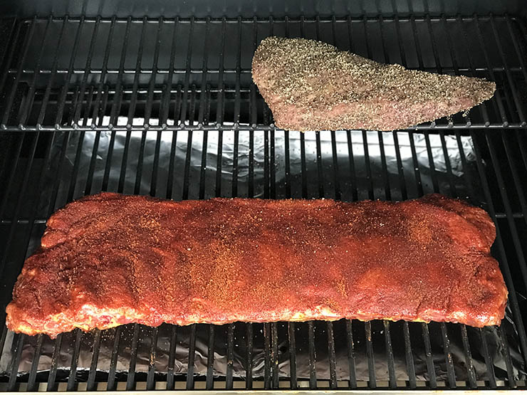 pork ribs and tri-tip cooking on a pellet grill
